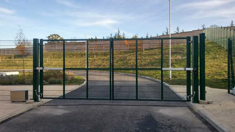 Existing green metal double gates at a fenced site entrance