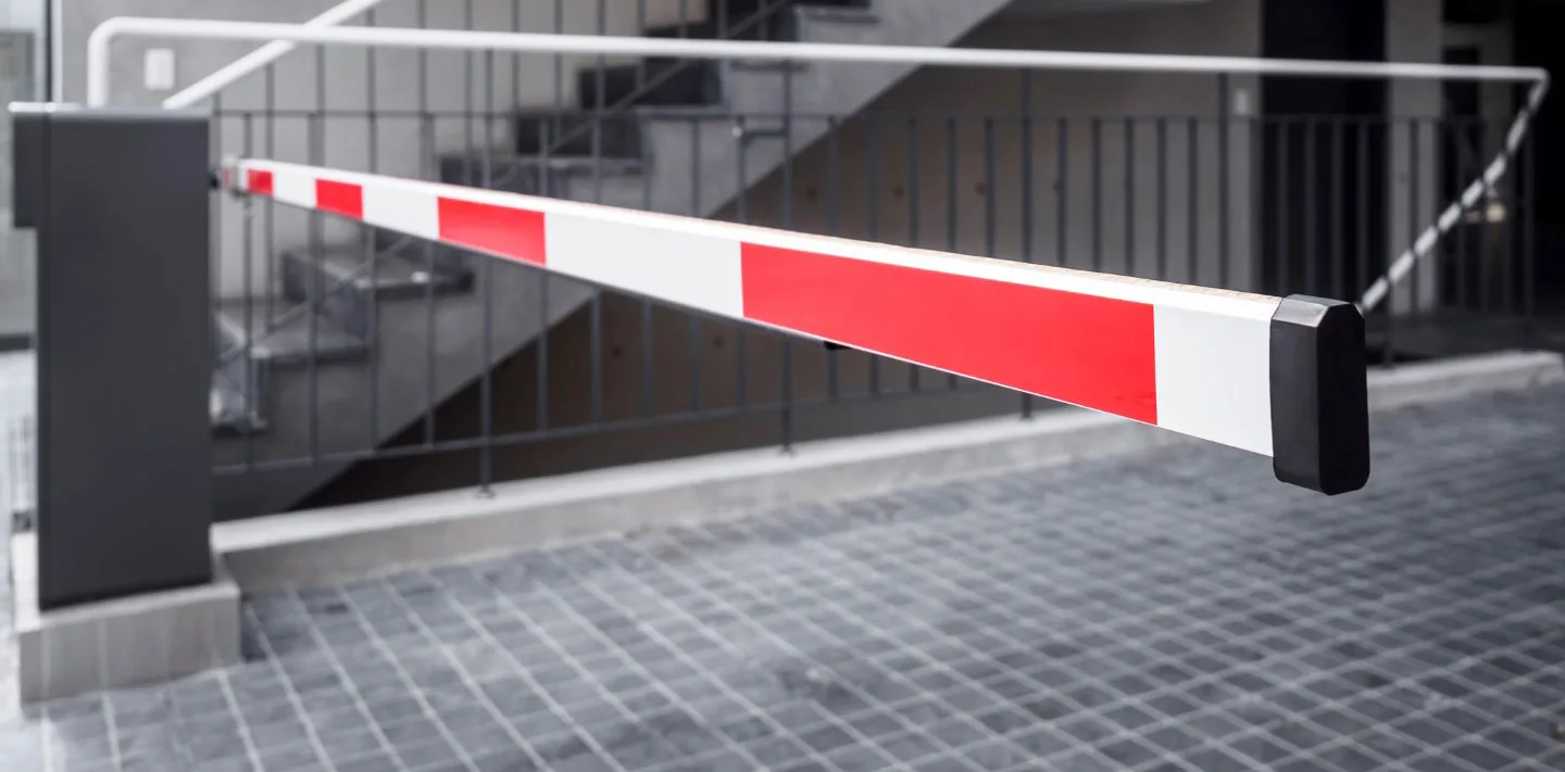 Red and white vehicle barrier across an entrance
