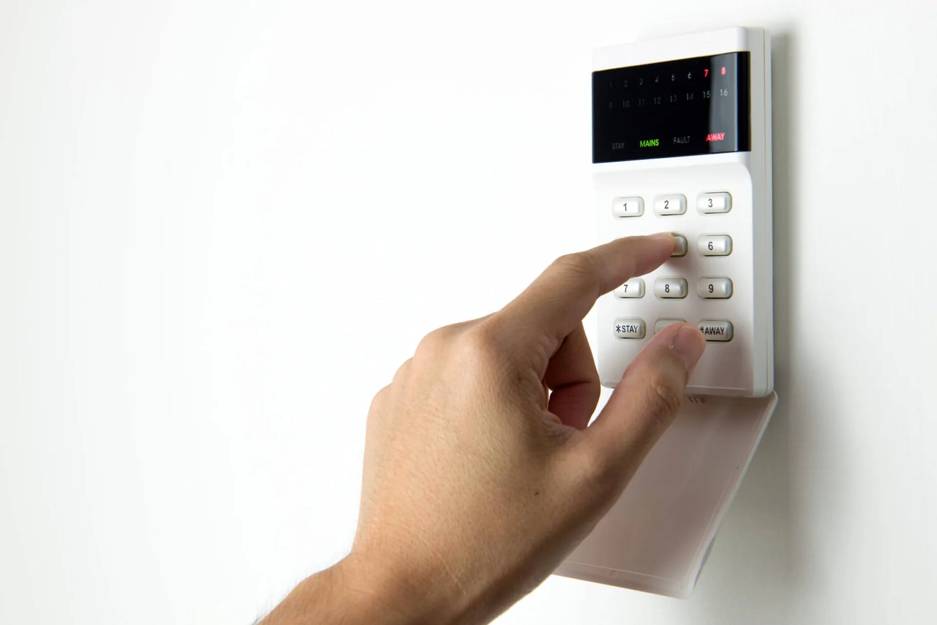 A person entering a code on a home alarm keypad